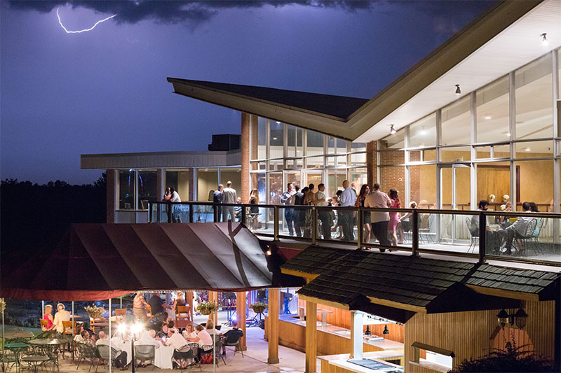 guests around the clubhouse at an evening event